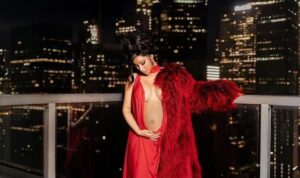 Cardi B Debuts Her Baby Bump In A Crimson Slip Gown With Cutouts And A Fur Coat Looking Extremely Gorgeous.. See More